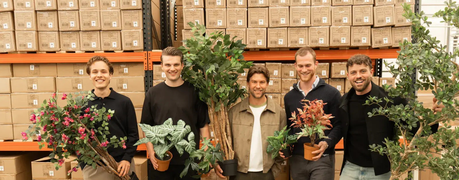Het team van Florafy in het magazijn met kunstplanten en kunstbomen